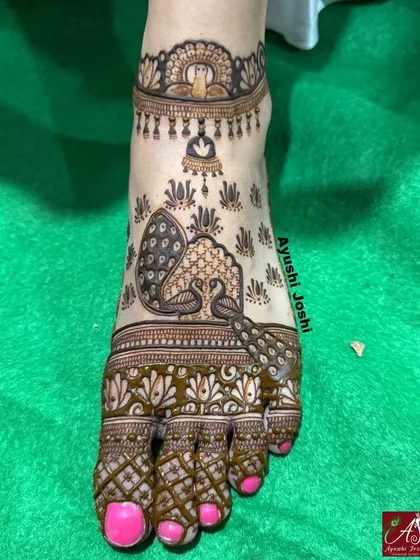 A beautiful foot design featuring peacocks and a representation of the Buddha, creating a serene and spiritual look.