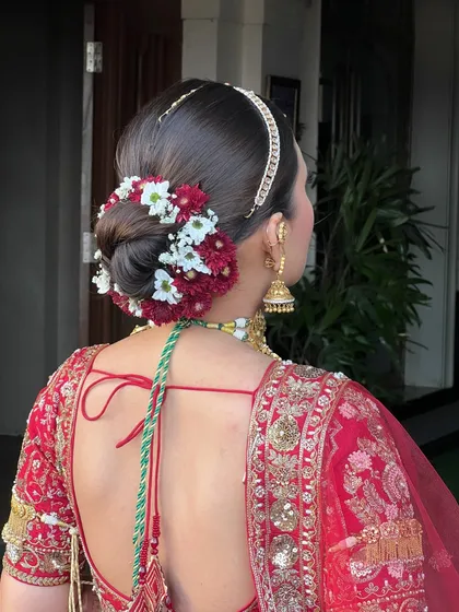 A hairstyle can complete the entire bridal vision. My sister Shakshi is an expert at creating intricate and beautiful hairstyles, like this stunning floral bun for a classic bridal look.