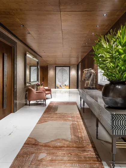An entrance lobby should be an immersive introduction to the home. In this Camellias apartment, we layered textures like ribbed wood veneers, Italian marble, and a hand-knotted rug to create a passage that is both grand in scale and warm in feeling, setting a tone of discovered richness.