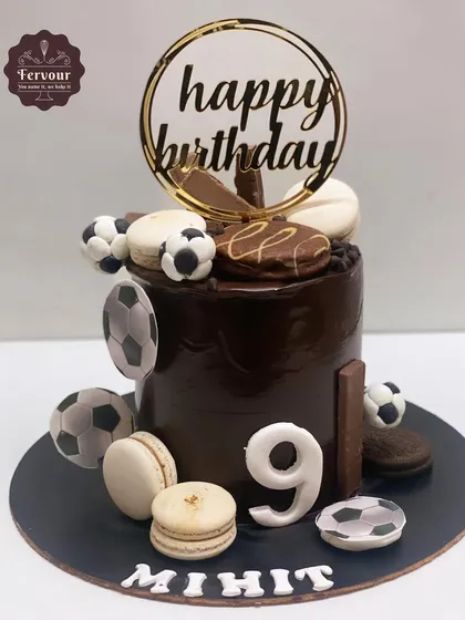 A football theme cake with a chocolate truffle flavour. This cake is decorated with macarons and printed footballs, perfect for a 19th birthday celebration.