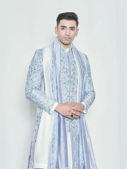 A full-length studio shot of the powder blue sherwani, demonstrating its flawless fit and regal silhouette. The coordinated accessories complete this bespoke groom's outfit.
