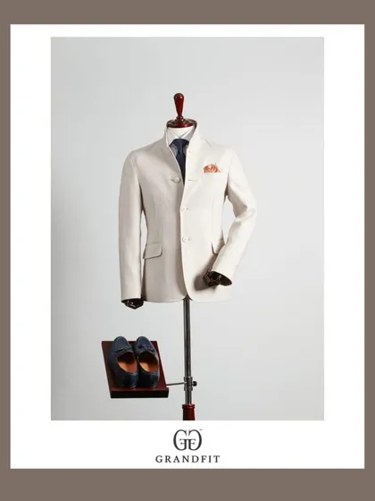 Showcasing the structure and fabric of a bespoke Bandhgala jacket. This piece, crafted from a light-colored premium material, is ideal for daytime events and formal gatherings.