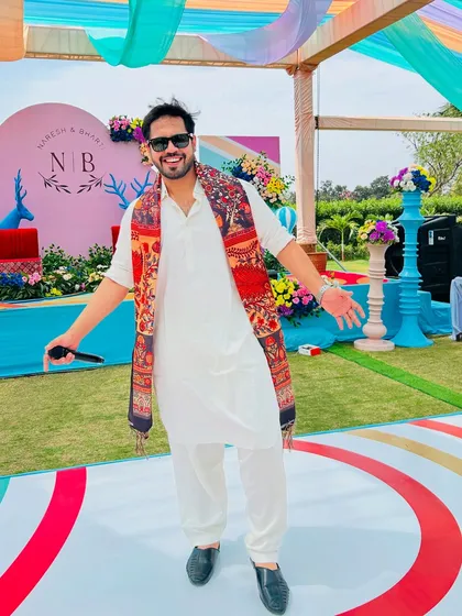 A full-length shot at a colorful Mehndi carnival. My job is to be the center of energy, inviting everyone to join the celebration.