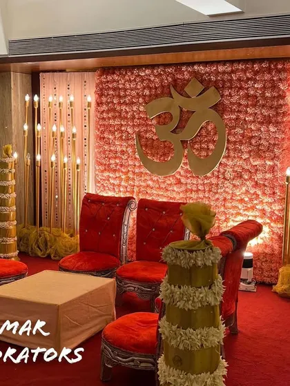 Another view of the intimate wedding ceremony stage. The combination of the floral wall, warm lighting, and traditional seating creates a beautiful and memorable setting for the rituals.