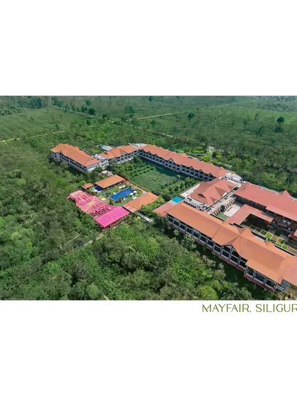 An aerial shot showcasing the sprawling Mayfair resort in Siliguri, nestled in lush greenery. This was the beautiful setting for Puja and Divesh's intimate wedding, surrounded by tea gardens.