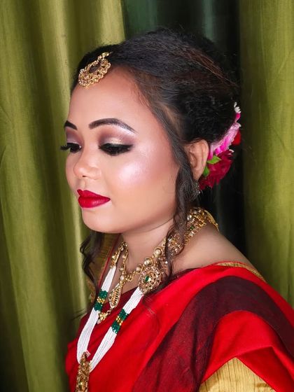 A side view showing the complete hairstyle with floral accessories and the beautiful drape of her saree.