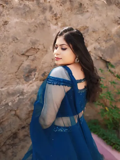 A side profile showing the soft waves in her hair and the flawless base makeup. This is a great angle to see the highlighter's glow.