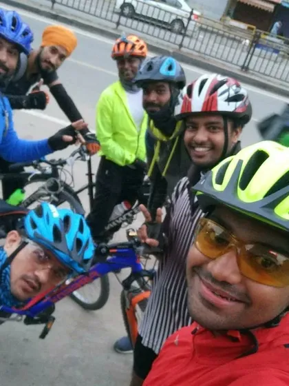 A smiling selfie with the group on the road, helmets on and ready to keep pedaling.