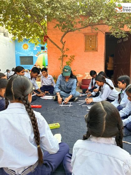 The workshop in session, with students sitting on the floor, deeply engaged in their craft. This informal setting encourages collaboration and creativity.
