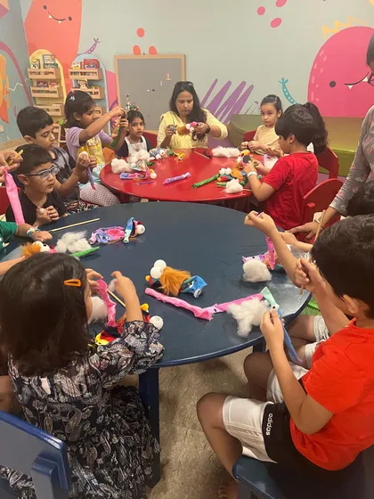 A table full of busy hands and creative minds. Our instructors guide the children as they work together to build their puppets from scratch.