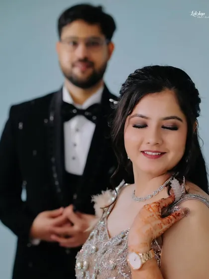 A beautiful portrait focusing on the bride, with the groom standing proudly in the background. This style of shot highlights both individuals while showing their connection.
