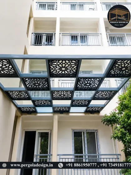 This apartment balcony is enhanced with a glass and CNC-cut panel pergola. The design adds a layer of sophistication and privacy, transforming a simple balcony into a more luxurious outdoor space.