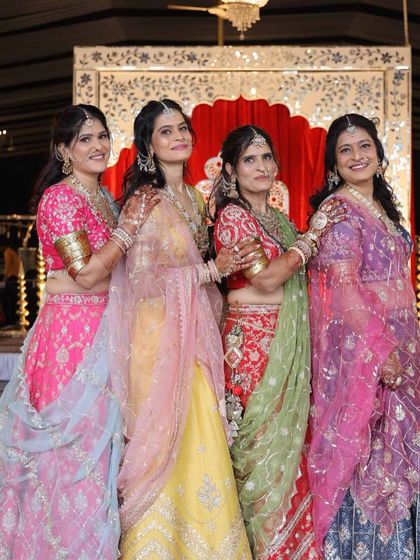 The ladies of the family, all dressed in custom Kaara lehengas for a Mayra ceremony. Each outfit, from pink and yellow to red and blue, was designed to complement the others while celebrating individual style.