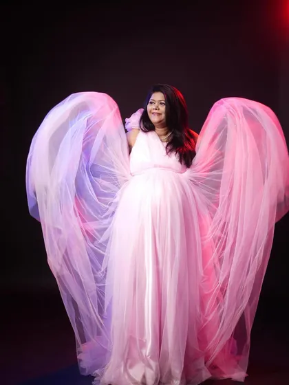 For a touch of magic, I use lighting and flowing fabrics to create dramatic, angel-like portraits. This pink maternity gown is a popular rental choice for moms-to-be who want a glamorous look.