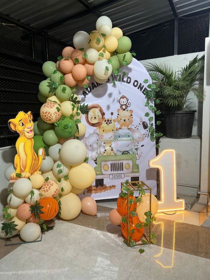 Another angle of the 'Wild One' jungle safari setup, showing the full scope of the balloon arch and the placement of the light-up number and decorative elements.