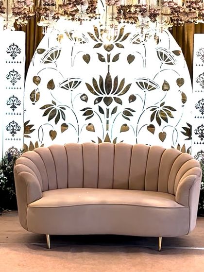 The stunning lotus and elephant motif stage, featuring a scalloped sofa and intricate jali work, perfect for a grand and artistic wedding.