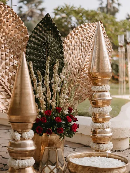 The combination of brass, woven natural fibers, and fresh flowers creates a rich, traditional aesthetic.