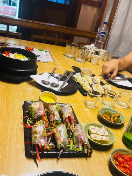 A close-up of a full Korean table setting, including bibimbap, dumplings, and various banchan (side dishes). I focus on making the food look as delicious as it tastes, enticing viewers to try it for themselves.