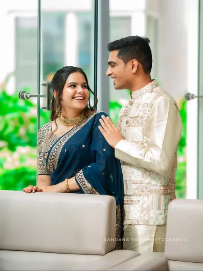 An engaged couple shares a sweet, candid moment during their indoor photoshoot. I use natural light from the large windows to create a soft, romantic feel for pre-wedding portraits.