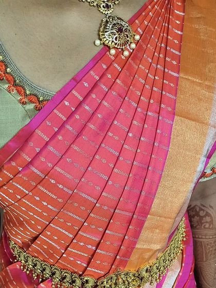 A close-up of the shoulder pleats for bride Preethi. The pleats are evenly spaced and pinned securely to create a neat, fan-like effect that stays in place.