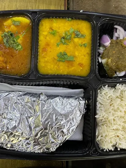 This thali features soft aloo koftas in a light gravy, served with yellow dal. The koftas are made from potatoes and are a delicious change from the usual sabzi.