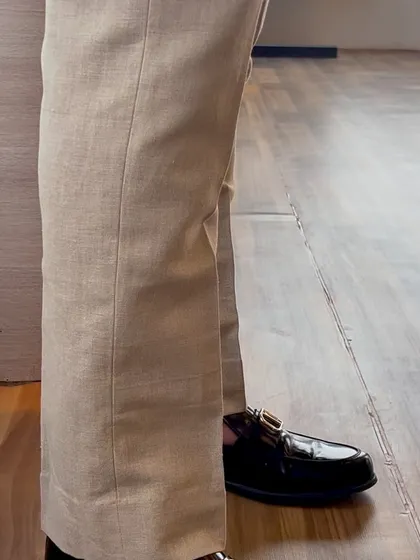 The break of the beige linen trousers over the shoe is tailored perfectly. Even in casual wear, we ensure every detail contributes to a clean and polished look.