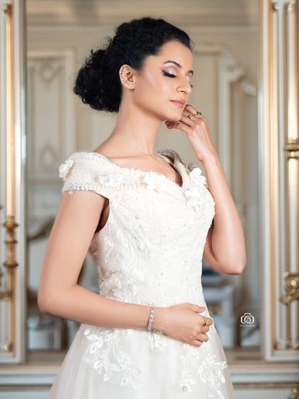 A beautiful studio portrait in a white gown, with a soft, painterly background. The elegant pose and classic styling give this image a timeless, romantic feel.