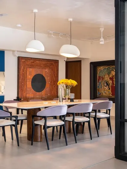 We believe in using color with confidence. In this open-plan Vile Parle apartment, a bold blue kitchen becomes the vibrant heart of the home, seamlessly connecting to the dining area. The custom dining table and chairs, along with striking artwork, create a space perfect for entertaining.