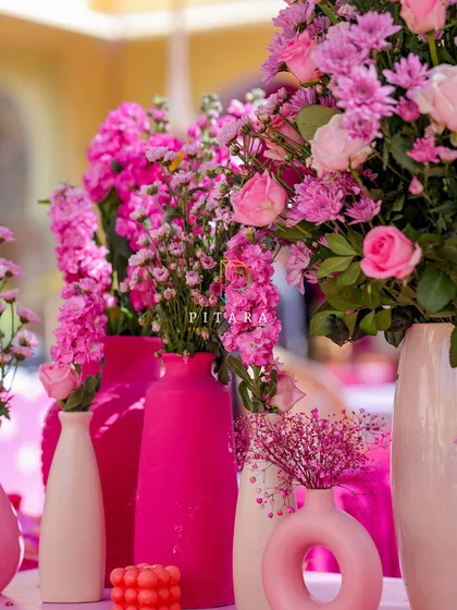 A close-up on the variety of modern vases we used, from textured ceramic to sleek, donut-shaped designs. The mix of shapes and shades of pink adds visual interest and sophistication.
