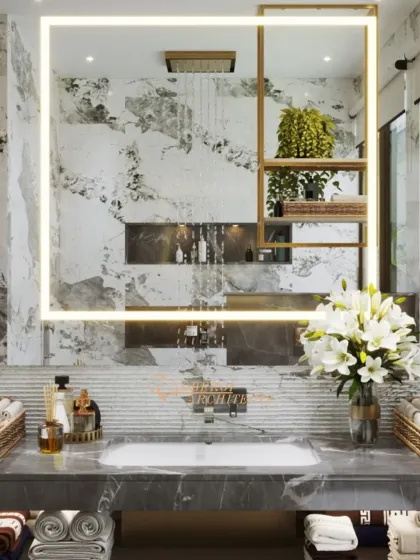 A close-up of the backlit mirror, which features an integrated gold-accented shelf, reflecting the rain shower and creating a sense of depth.