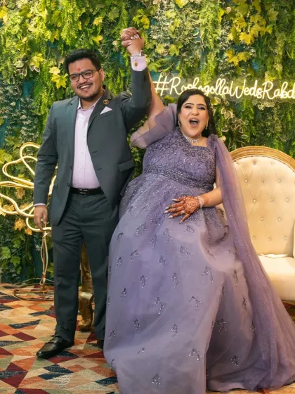 Pure joy! The couple celebrates their engagement with arms raised in victory, a perfect candid moment.