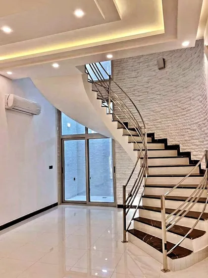 My work seamlessly integrates with your home's architecture. Here, I've added a textured white brick accent wall that complements the modern staircase, adding texture and visual interest to the double-height space.