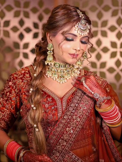 A close-up on the bridal jewelry and makeup, perfectly complementing the rich tones of the rental lehenga.