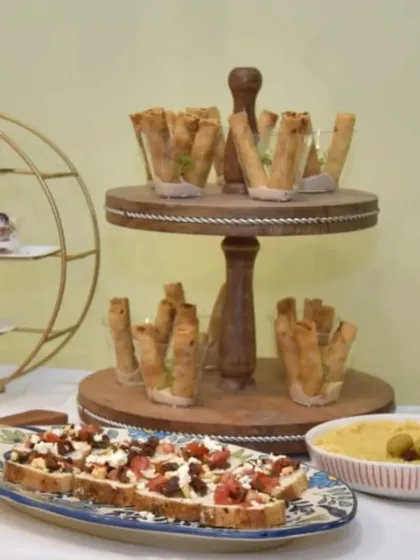 A display of our popular appetizers, including our signature Truffle Cigar Rolls and a platter of fresh bruschetta with feta and tomatoes.