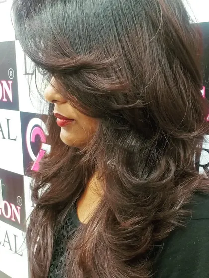 A side profile of a long layered haircut with face-framing pieces. This style is timeless and flattering for many face shapes.