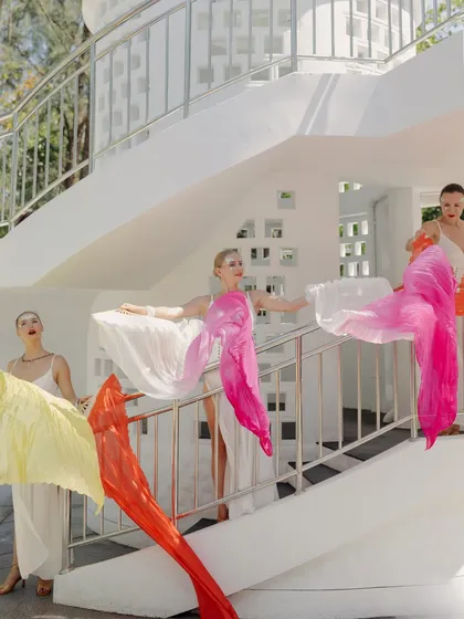 Dancers with colorful, flowing fans add a touch of whimsy and movement to the welcome celebrations, creating a vibrant and dynamic atmosphere.