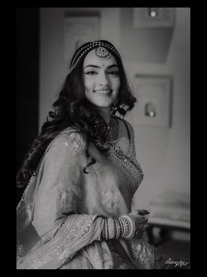 A classic, smiling black and white portrait of a beautiful bride.