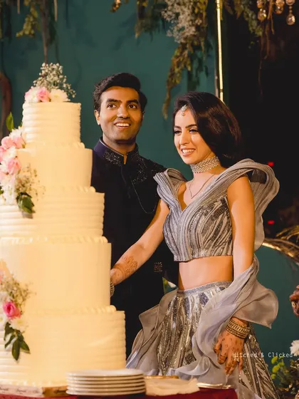 A joyful cake cutting moment at an elegant outdoor reception. The towering cake, adorned with fresh flowers, becomes a beautiful centerpiece for the celebration.