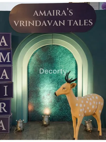 A close-up of the entrance to "Amaira's Vrindavan Tales," featuring a deer prop and personalized blocks.
