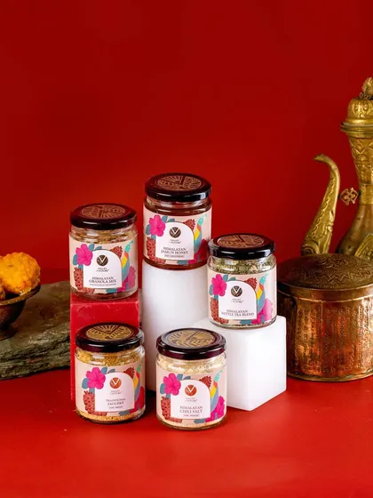 A close-up of Valley Culture's product jars, arranged for a festive theme. The warm lighting and traditional brassware make this a beautiful shot for holiday marketing.