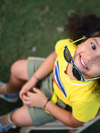 A fun, high-angle shot of a smiling girl during her outdoor session. I love finding creative angles to capture a child's personality and joy.