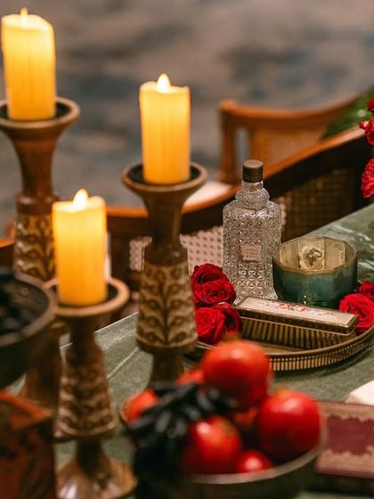 A tablescape that tells a story. We used elements like vintage books, brass objects, and bowls of fruit to create a still life reminiscent of the details found in Raja Ravi Varma's work.