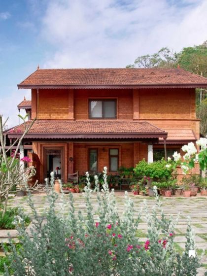 The Varadarajan House, built with a rich palette of terracotta laterite and crowned with a traditional tiled roof. The design creates a serene hill retreat that honors the cultural heritage and natural beauty of Coorg.