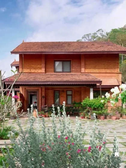 The Varadarajan House, with its terracotta-clad facade and tiled roofs, is designed as a serene hill retreat that harmonizes with the Coorg rainforest. The home's design evolved from a desire to connect with the garden and the valley view.