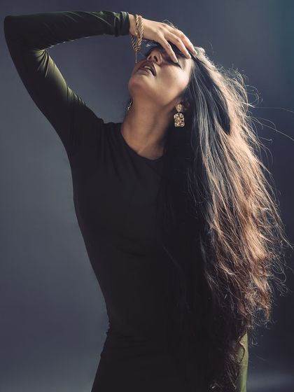 A graceful and dramatic pose, highlighting the model's long hair and the elegant lines of her body.