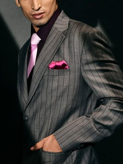 The fine pinstripes and the bold color combination make this suit a standout piece for any formal occasion.