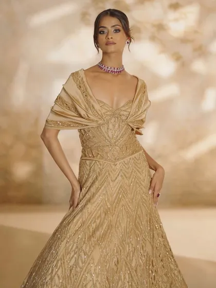 Golden hour in couture form. This embellished gown features a flared bottom and a draped bodice, creating a silhouette of pure elegance in motion.