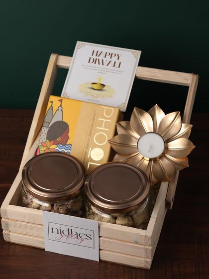 A duplicate of ID 132, this hamper combines two jars of nuts, Phool incense cones, and a golden flower diya in a wooden basket, offering a touch of luxury on a budget.