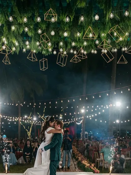 This is what a high-energy Sangeet night looks like. I combined a canopy of lush greenery with geometric lanterns and string lights to create a magical, open-air dance floor where the couple could celebrate under the stars.