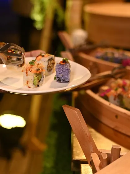 A guest selects their favourite rolls from our live sushi station, showcasing the interactive and personalized nature of the experience.